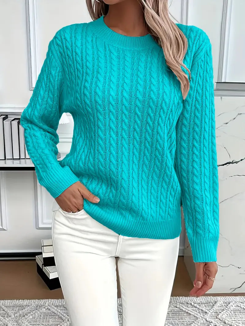 Peacock Blue - Women's light pink cable knit sweater with long sleeves and a crew neckline, worn with white pants.