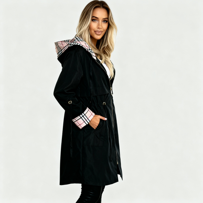 Black - A woman wearing a taupe mid-length hooded jacket with a black zip front, featuring a distinctive black, white, and red check lining visible in the hood and rolled cuffs.