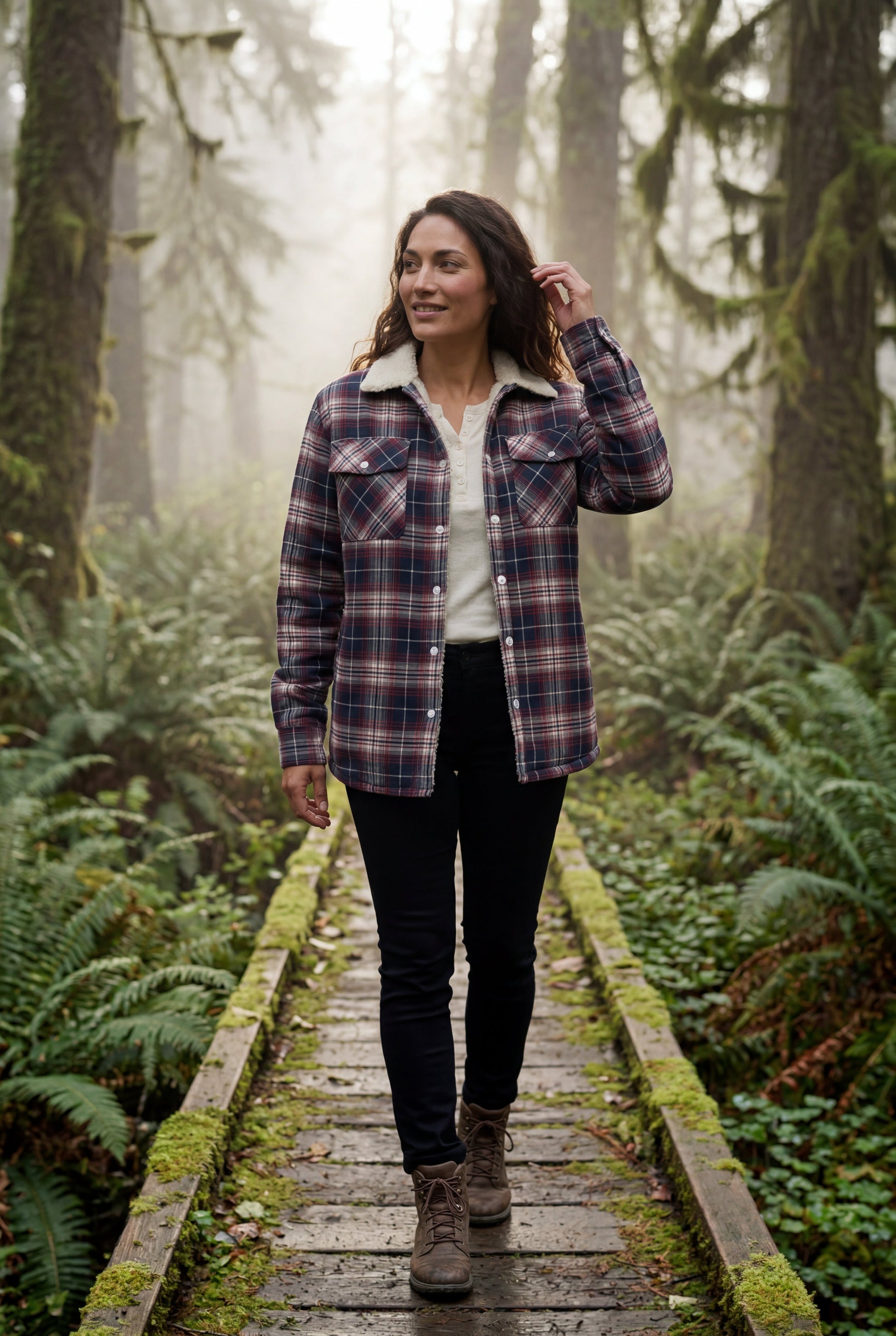 Orange - A woman wearing a brown plaid flannel shirt jacket with a cream shearling lining, paired with dark wash jeans and brown leather boots.