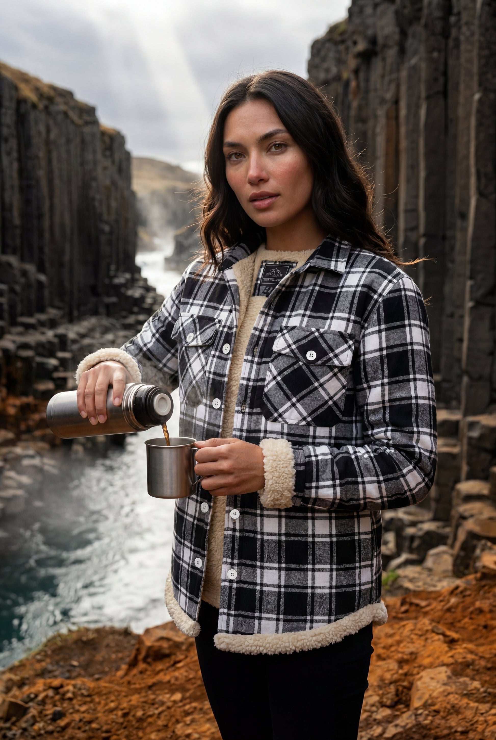 Orange - A woman wearing a brown plaid flannel shirt jacket with a cream shearling lining, paired with dark wash jeans and brown leather boots.