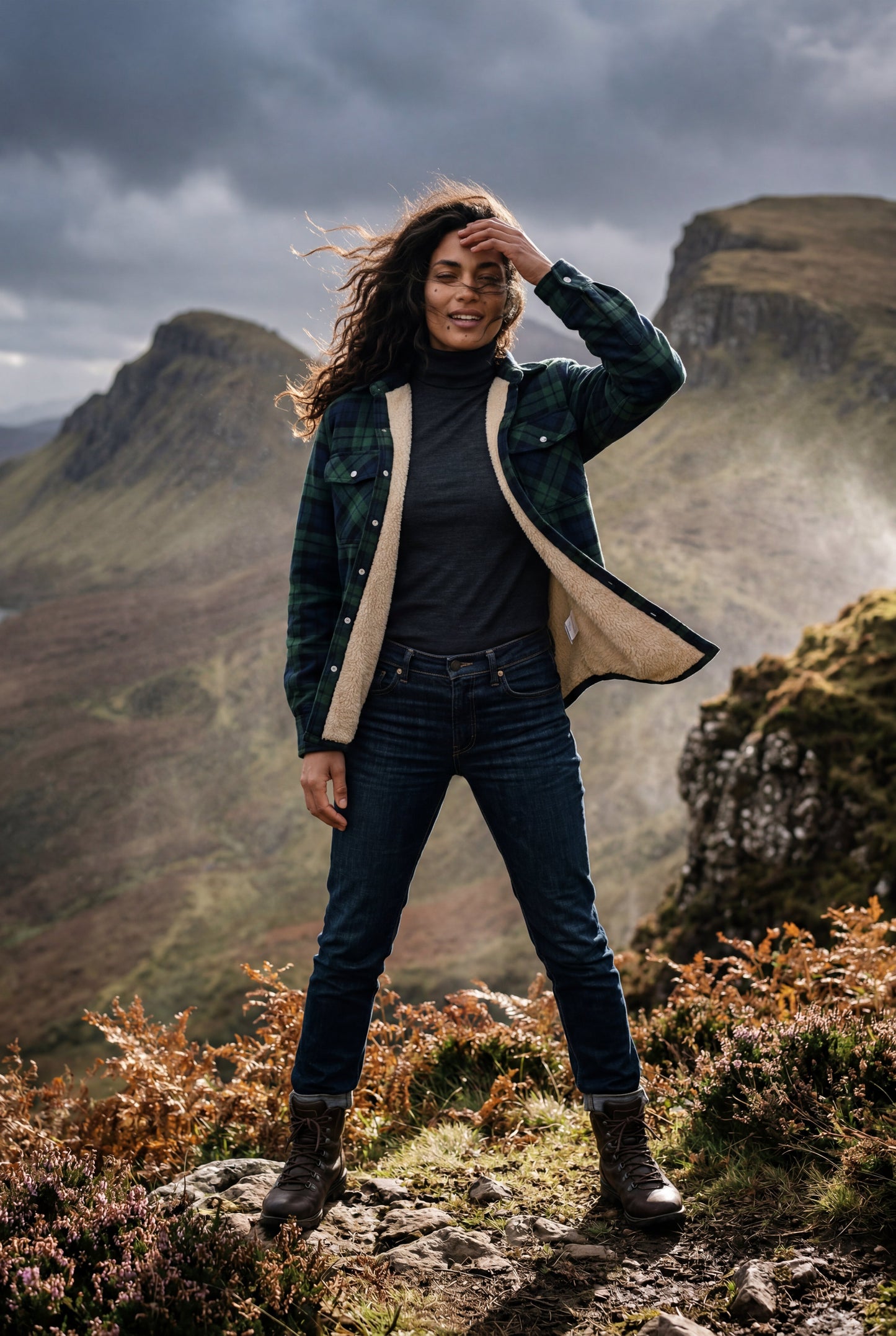 Green - A woman wearing a brown plaid flannel shirt jacket with a cream shearling lining, paired with dark wash jeans and brown leather boots.