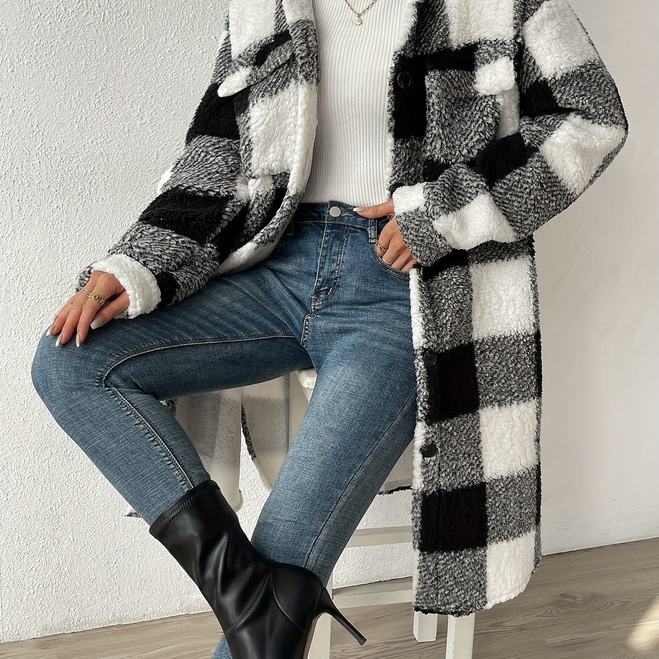 Black - Women's longline teddy coat featuring a large pink and white check pattern, collared neckline, and button-front closure, styled over a ribbed knit top and white denim.
