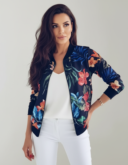Blue - A woman wearing a white bomber jacket featuring a detailed pink cherry blossom and green leaf print, styled with black pants against a neutral grey background.