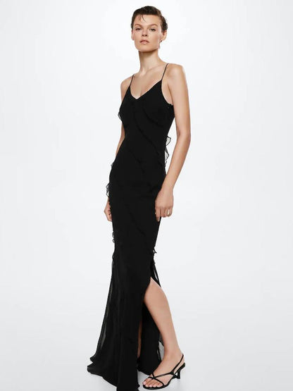 Red - A woman wearing a vibrant red chiffon maxi dress with cascading diagonal ruffles, a V-neckline, and thin spaghetti straps, posing against a rustic dark wooden door.
