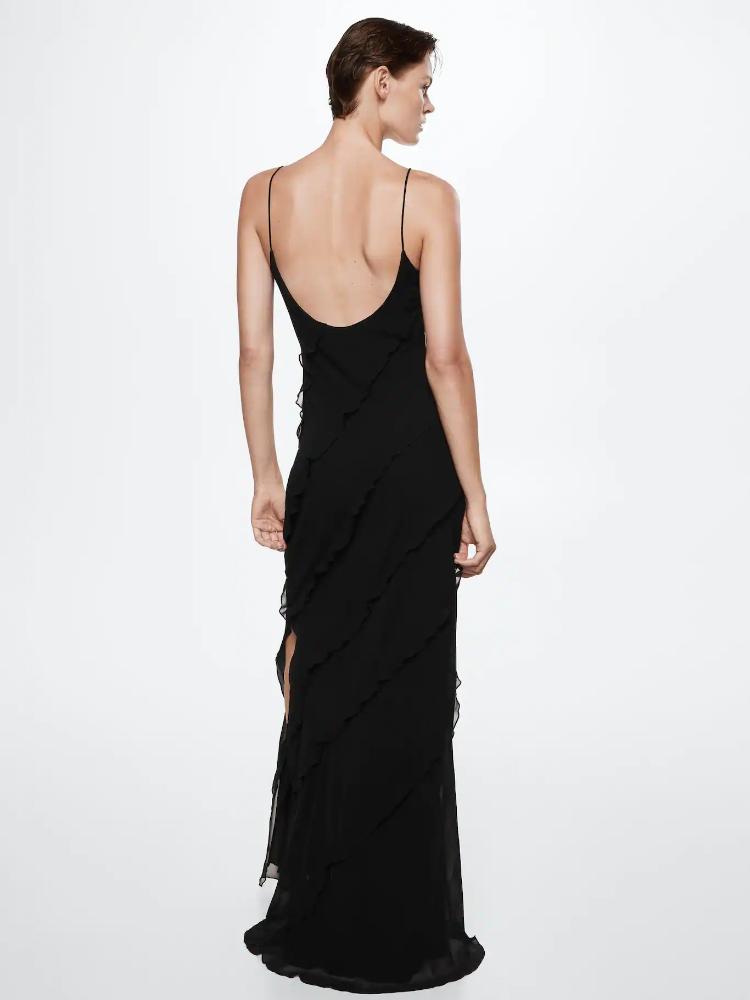 Red - A woman wearing a vibrant red chiffon maxi dress with cascading diagonal ruffles, a V-neckline, and thin spaghetti straps, posing against a rustic dark wooden door.