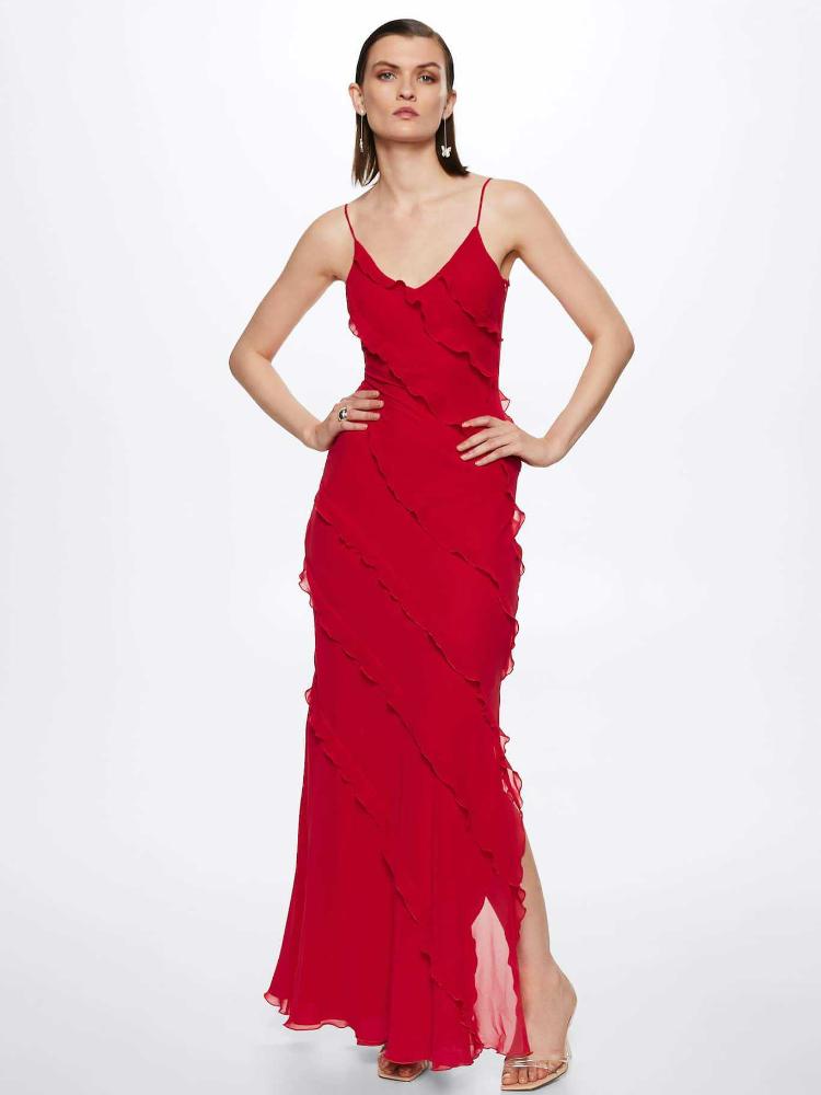 Red - A woman wearing a vibrant red chiffon maxi dress with cascading diagonal ruffles, a V-neckline, and thin spaghetti straps, posing against a rustic dark wooden door.