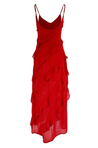 Red - A woman wearing a vibrant red chiffon maxi dress with cascading diagonal ruffles, a V-neckline, and thin spaghetti straps, posing against a rustic dark wooden door.
