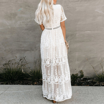Women's resort maxi dress featuring a deep V-neckline, short flutter sleeves, and intricate floral lace embroidery on a sheer overlay with a partial lining.