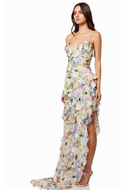Green - A model wearing a sleeveless maxi dress in a pastel floral print chiffon, featuring cascading ruffles, a V-neckline, and an asymmetric hem with a train.