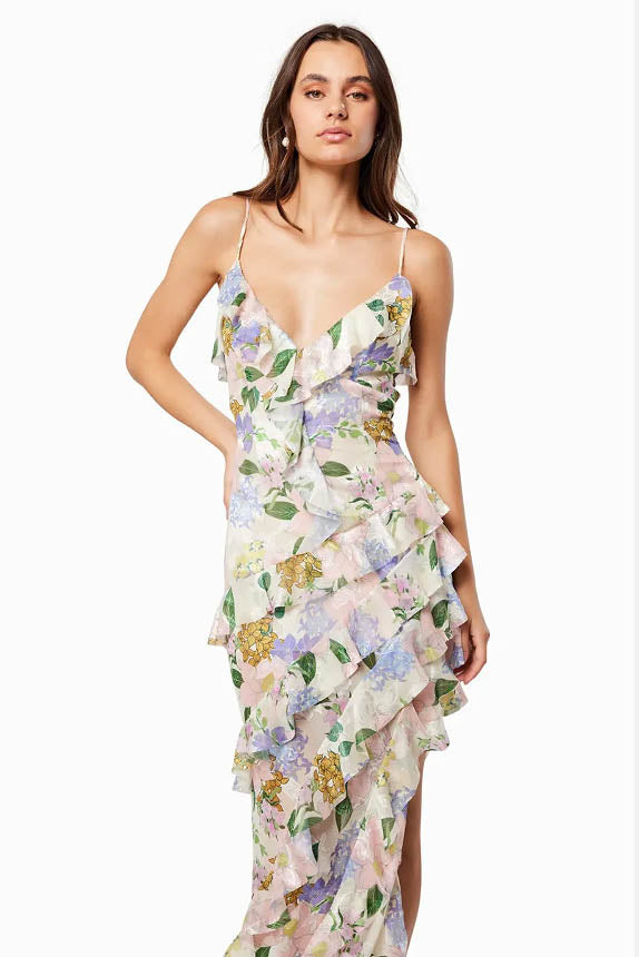 Green - A model wearing a sleeveless maxi dress in a pastel floral print chiffon, featuring cascading ruffles, a V-neckline, and an asymmetric hem with a train.