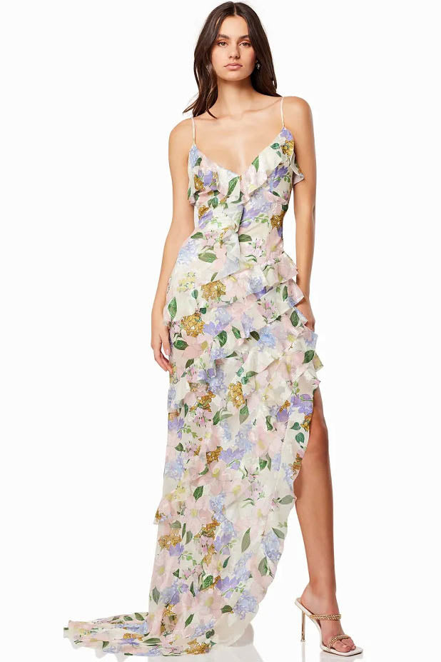 Green - A model wearing a sleeveless maxi dress in a pastel floral print chiffon, featuring cascading ruffles, a V-neckline, and an asymmetric hem with a train.