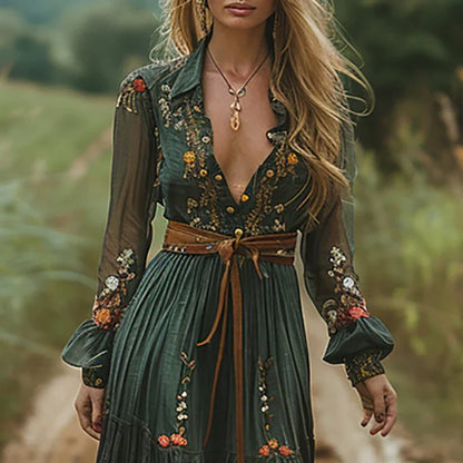 Green (Almost Sold Out) - A woman wearing a long sleeve georgette maxi dress featuring intricate floral embroidery, a button-up front, an adjustable tie waist, and a tiered flowing skirt.