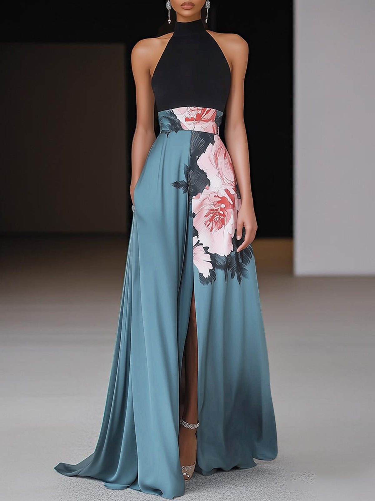 Black - Woman wearing a floor-length maxi dress featuring a solid halter top and a flowing skirt with a large floral placement print and a high front slit.