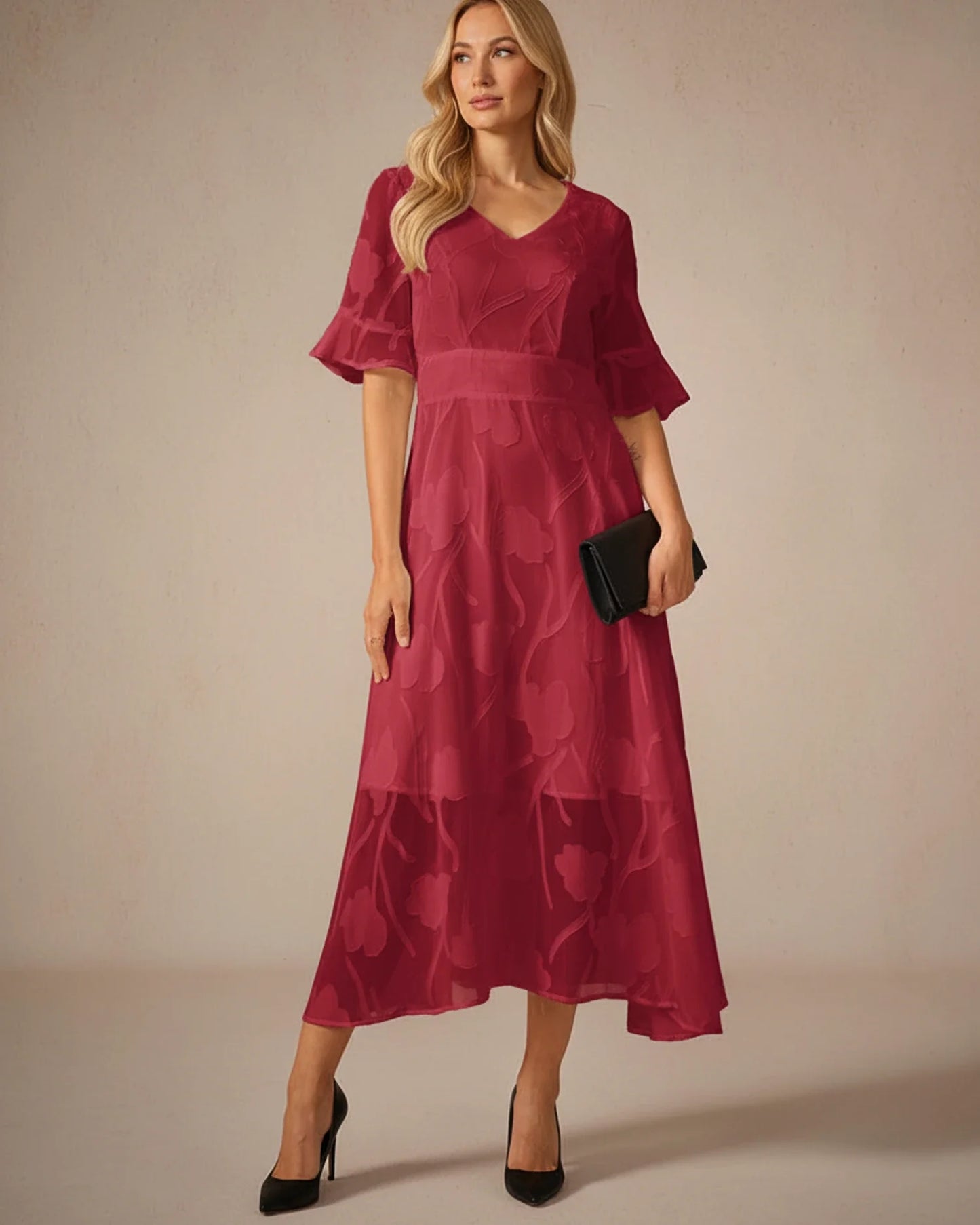 Red - A woman models a black formal midi dress featuring a V-neckline, flutter sleeves, and a textured floral jacquard overlay with a sheer hemline.