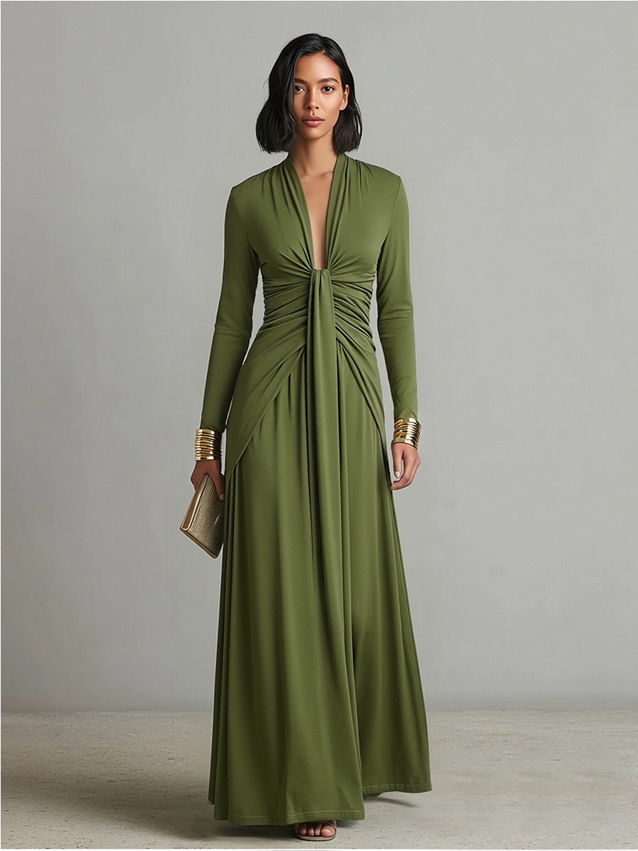 Green - A woman wears an olive green long-sleeve maxi dress crafted from fluid jersey, featuring a deep plunging V-neckline, a central ruched knot at the waist, and a cascading floor-length skirt.