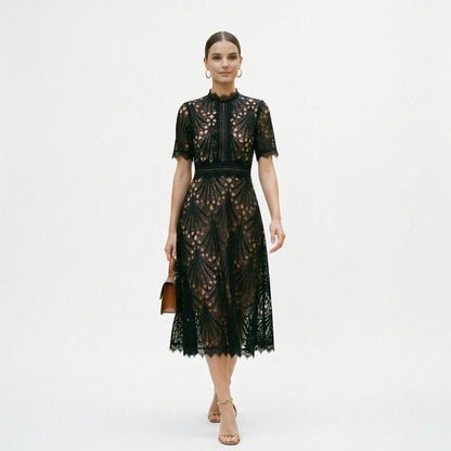 Black - A woman wearing a black geometric lace midi dress with a high neck, short sleeves, and a defined waist, featuring a nude lining and scalloped hem.