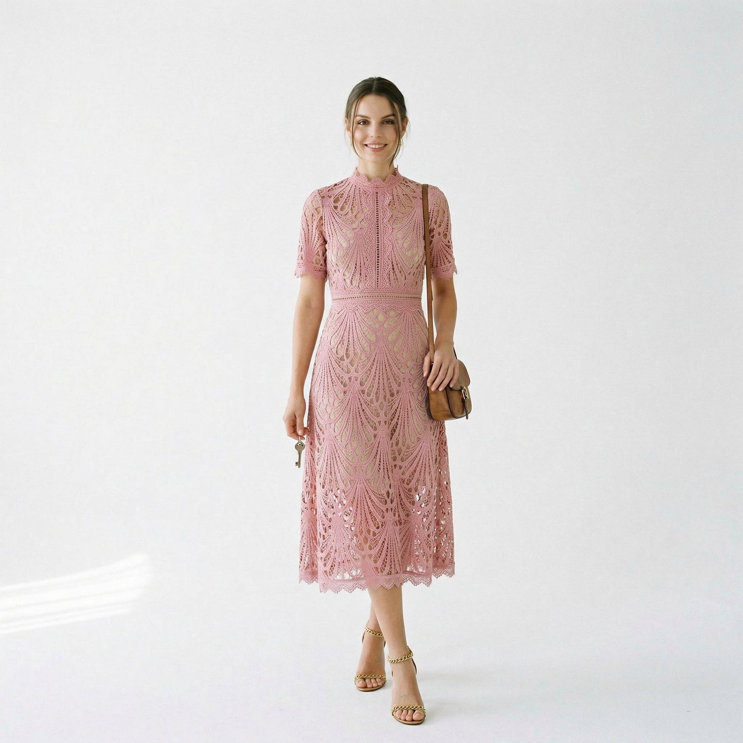 Pink - A woman wearing a black geometric lace midi dress with a high neck, short sleeves, and a defined waist, featuring a nude lining and scalloped hem.