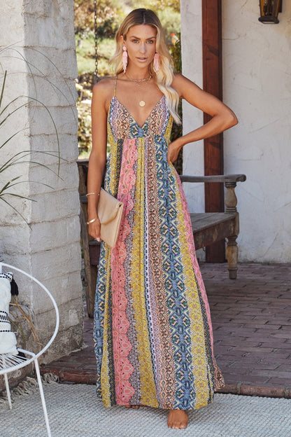 Multi - Women's resort maxi dress featuring a vibrant geometric and bohemian print, V-neckline, and delicate spaghetti straps, worn outdoors.