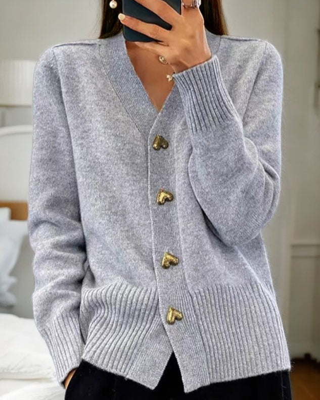 Grey - Women's grey V-neck knit cardigan featuring metallic gold heart-shaped buttons, drop shoulders, and wide ribbed cuffs and hem.