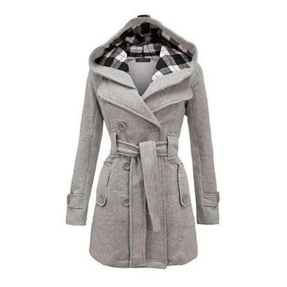 Light Grey - A woman wearing a cream-coloured, mid-length double-breasted trench coat with a hood, a tied waist belt, and black pants.