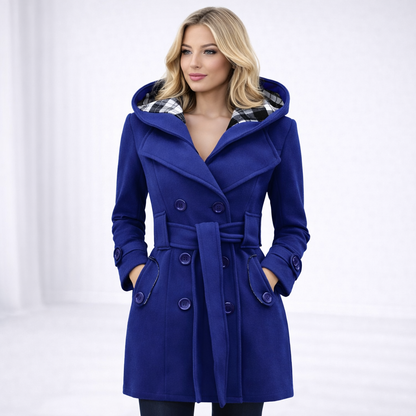 Blue - A woman wearing a cream-coloured, mid-length double-breasted trench coat with a hood, a tied waist belt, and black pants.