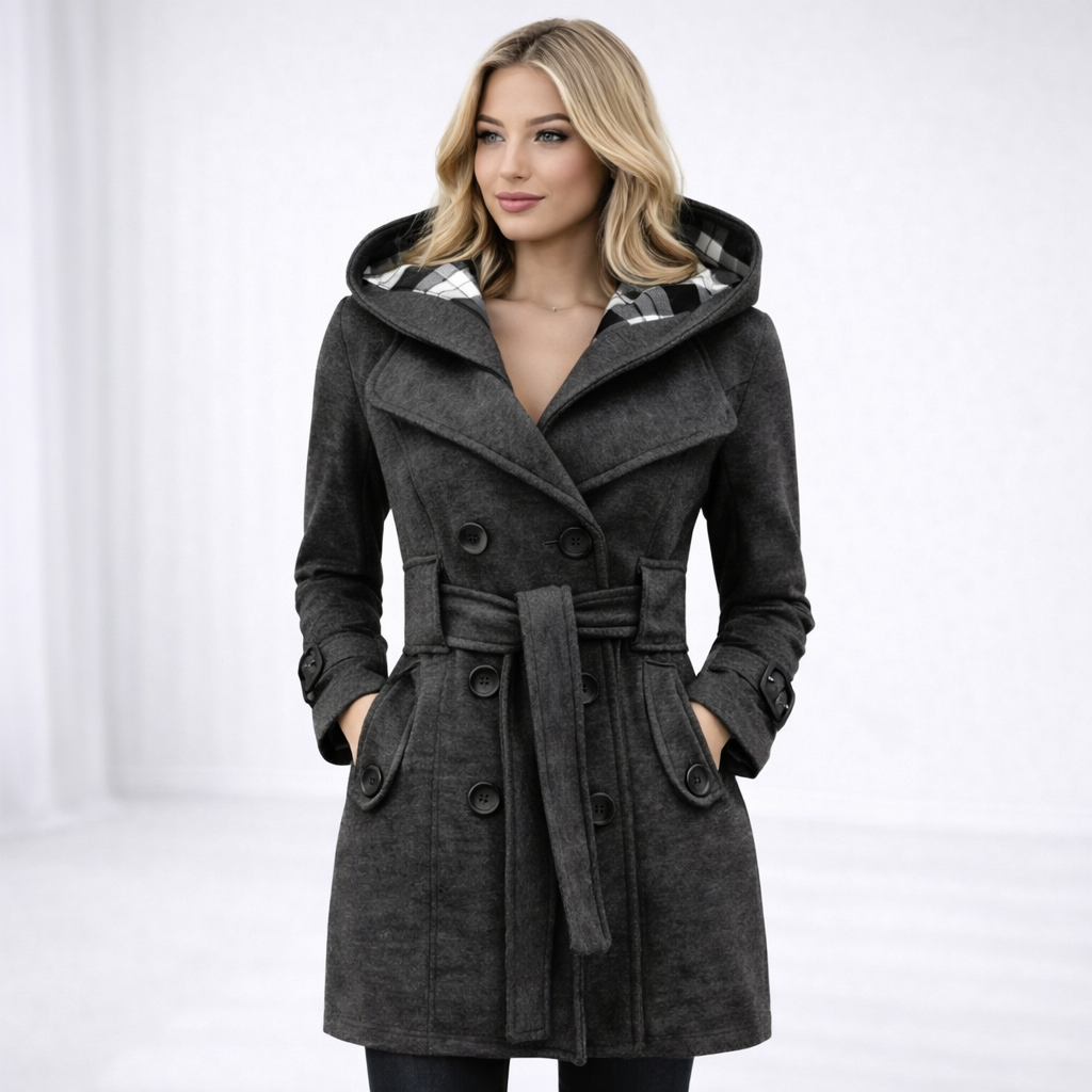 Grey - A woman wearing a cream-coloured, mid-length double-breasted trench coat with a hood, a tied waist belt, and black pants.