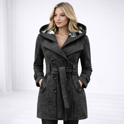 Grey - A woman wearing a cream-coloured, mid-length double-breasted trench coat with a hood, a tied waist belt, and black pants.