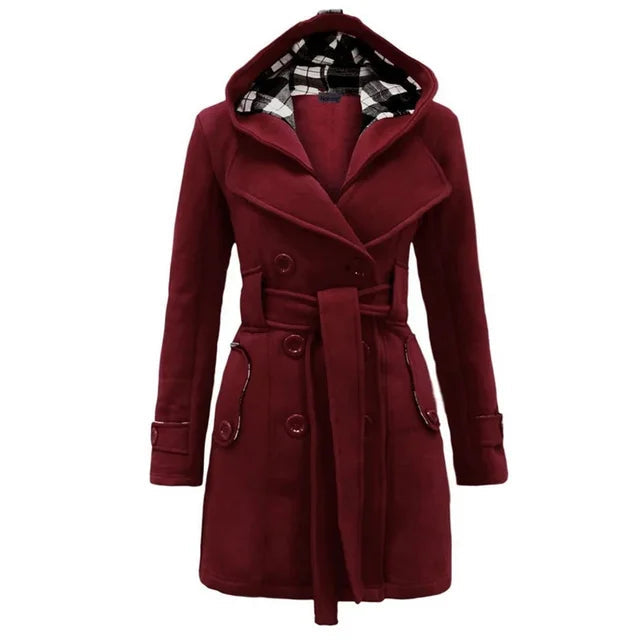 Bordeaux Red - A woman wearing a cream-coloured, mid-length double-breasted trench coat with a hood, a tied waist belt, and black pants.