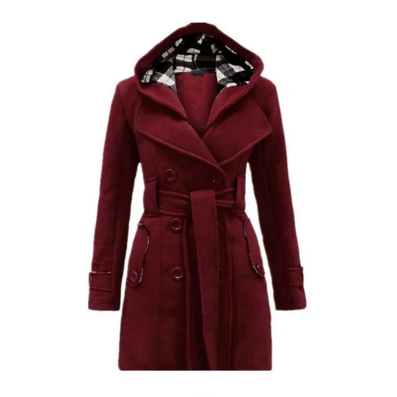 Bordeaux Red - A woman wearing a cream-coloured, mid-length double-breasted trench coat with a hood, a tied waist belt, and black pants.