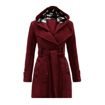 Bordeaux Red - A woman wearing a cream-coloured, mid-length double-breasted trench coat with a hood, a tied waist belt, and black pants.