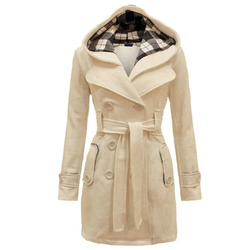 Bordeaux Red - A woman wearing a cream-coloured, mid-length double-breasted trench coat with a hood, a tied waist belt, and black pants.