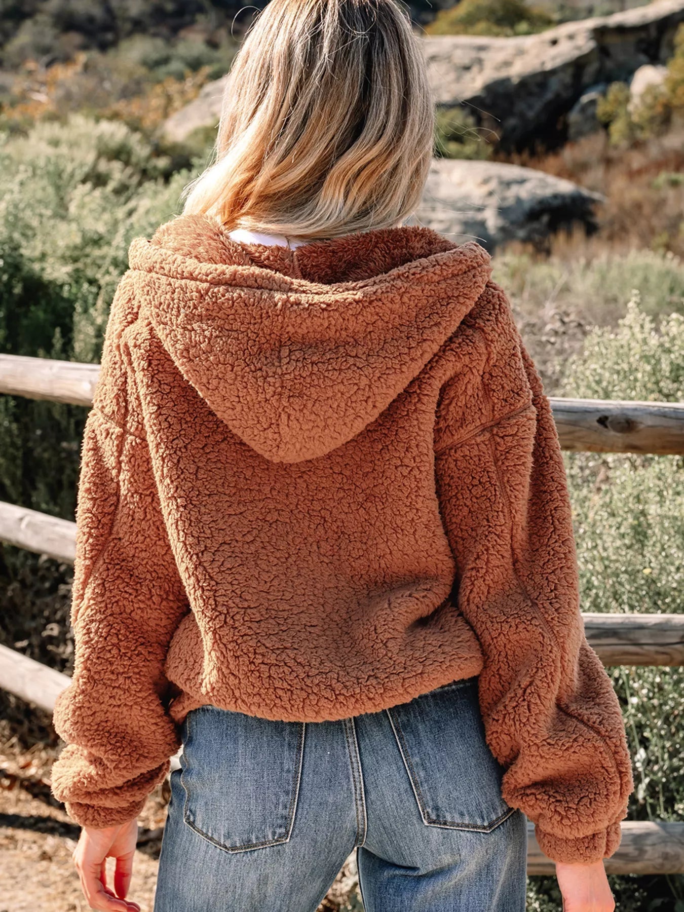 Brown - Women's brown hooded teddy fleece jacket with front zipper and patch pockets, worn over a white t-shirt and jeans.