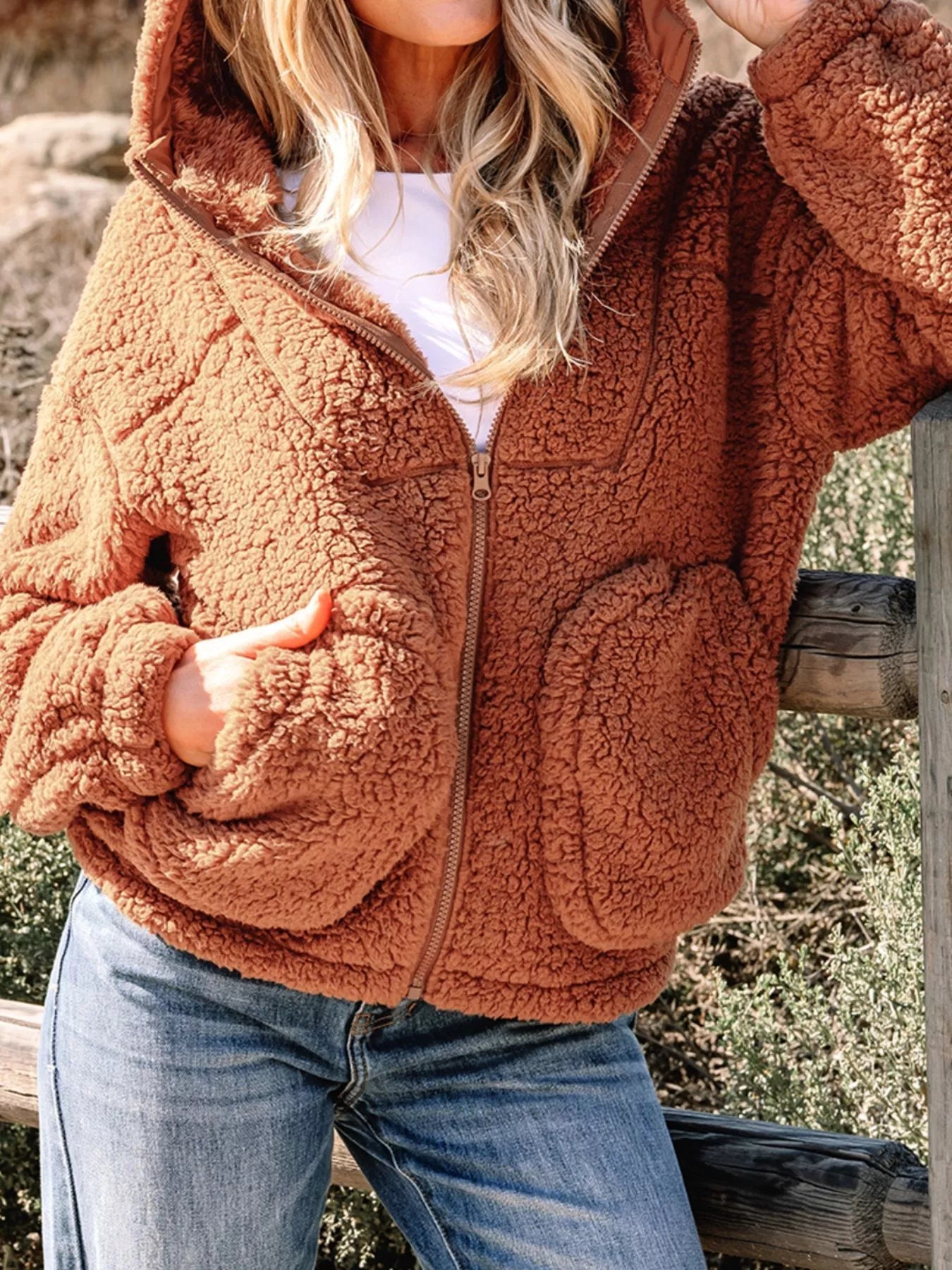 Brown - Women's brown hooded teddy fleece jacket with front zipper and patch pockets, worn over a white t-shirt and jeans.