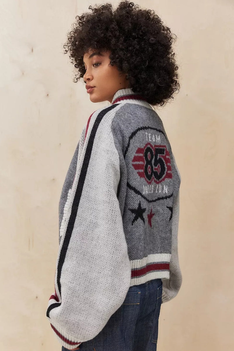 Gray - A model wearing a grey colour block knit bomber jacket with a zip front and sporty striped ribbed trims, paired with blue jeans.