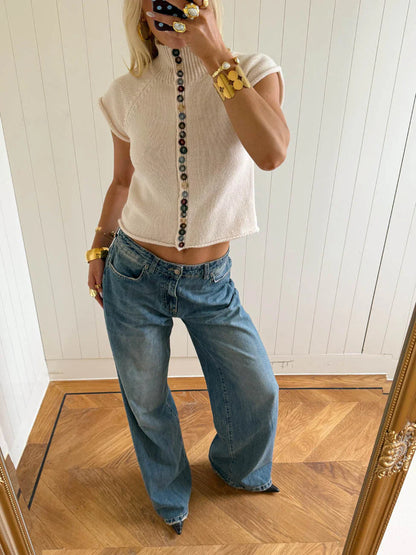 Beige - Women's cream-coloured short-sleeve knit top featuring a ribbed mock neck, rolled raglan sleeves, and a distinctive front closure with a long row of multi-coloured buttons.