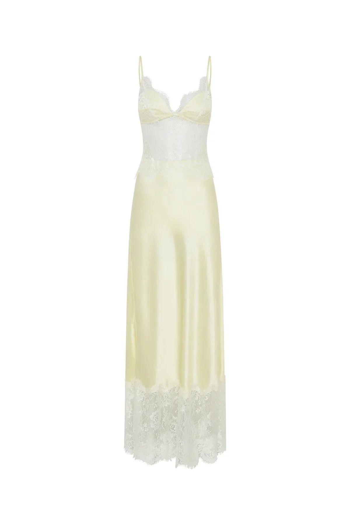 A woman wearing a pale yellow maxi slip dress featuring a sheer floral lace bodice, spaghetti straps, and a lustrous satin skirt finished with a wide scalloped lace hem.