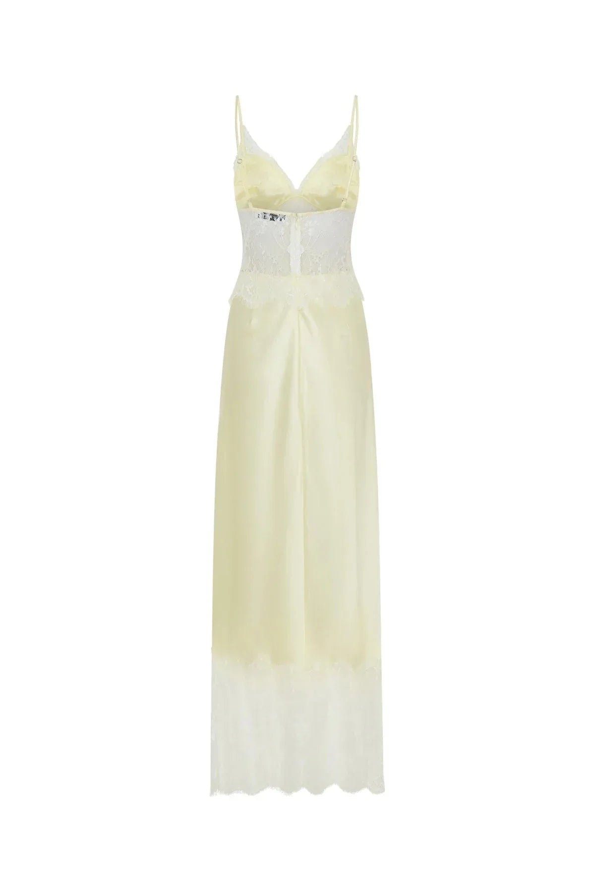A woman wearing a pale yellow maxi slip dress featuring a sheer floral lace bodice, spaghetti straps, and a lustrous satin skirt finished with a wide scalloped lace hem.