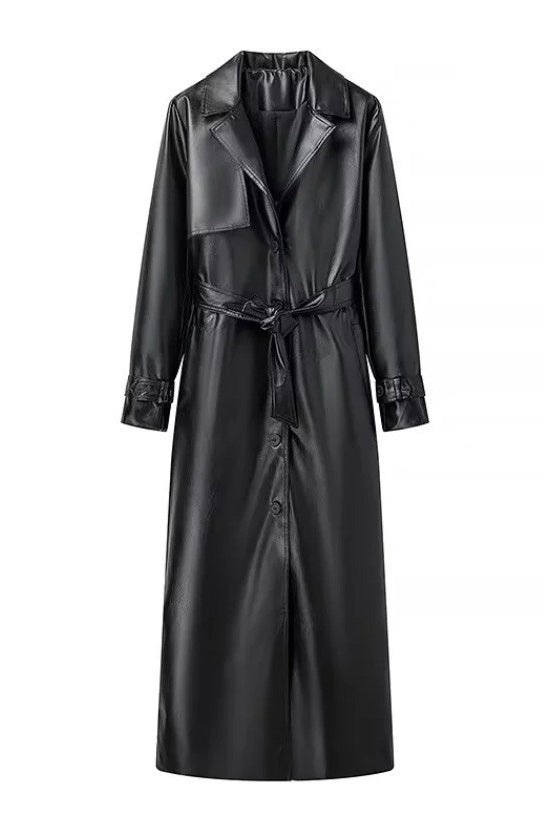 Black - A woman walking down a city street wearing a deep burgundy maxi-length trench coat in a smooth leather-look material, styled with a black turtleneck, black stirrup pants, and black heels.