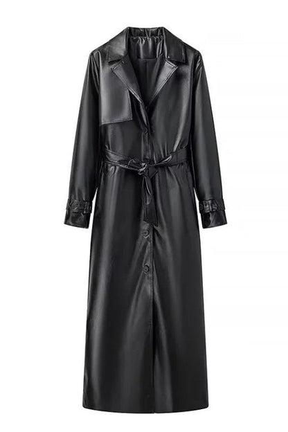 Black - A woman walking down a city street wearing a deep burgundy maxi-length trench coat in a smooth leather-look material, styled with a black turtleneck, black stirrup pants, and black heels.