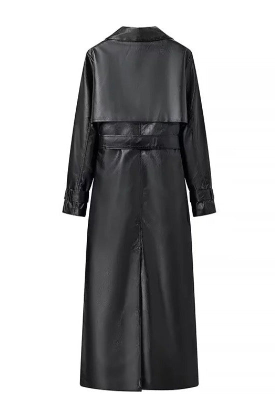 Black - A woman walking down a city street wearing a deep burgundy maxi-length trench coat in a smooth leather-look material, styled with a black turtleneck, black stirrup pants, and black heels.
