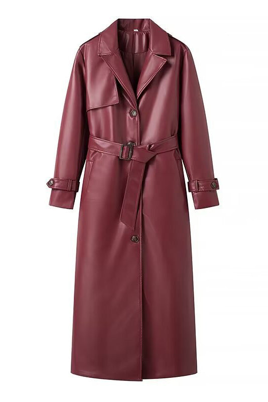 Red - A woman walking down a city street wearing a deep burgundy maxi-length trench coat in a smooth leather-look material, styled with a black turtleneck, black stirrup pants, and black heels.