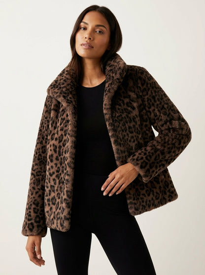 Dark Brown - A woman wearing a cropped leopard print faux fur jacket with a structured collar, styled over a black turtleneck and black leather pants.