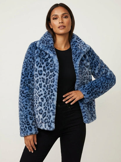 Blue - A woman wearing a cropped leopard print faux fur jacket with a structured collar, styled over a black turtleneck and black leather pants.