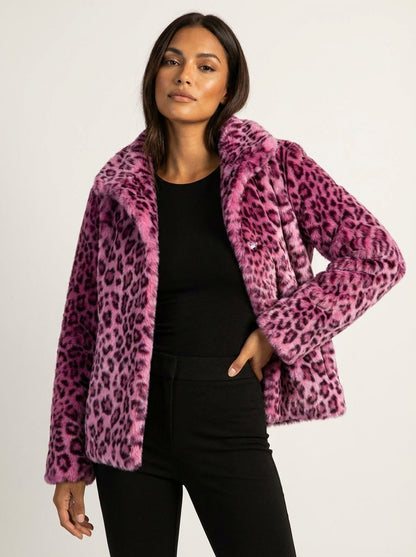 Pink - A woman wearing a cropped leopard print faux fur jacket with a structured collar, styled over a black turtleneck and black leather pants.
