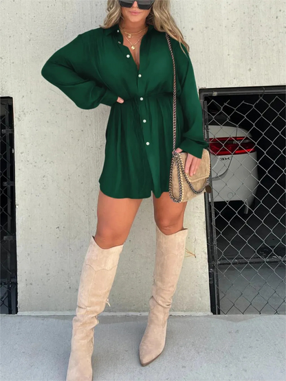 Green - Woman wearing a long sleeve button front shirt dress with an adjustable tie waist.