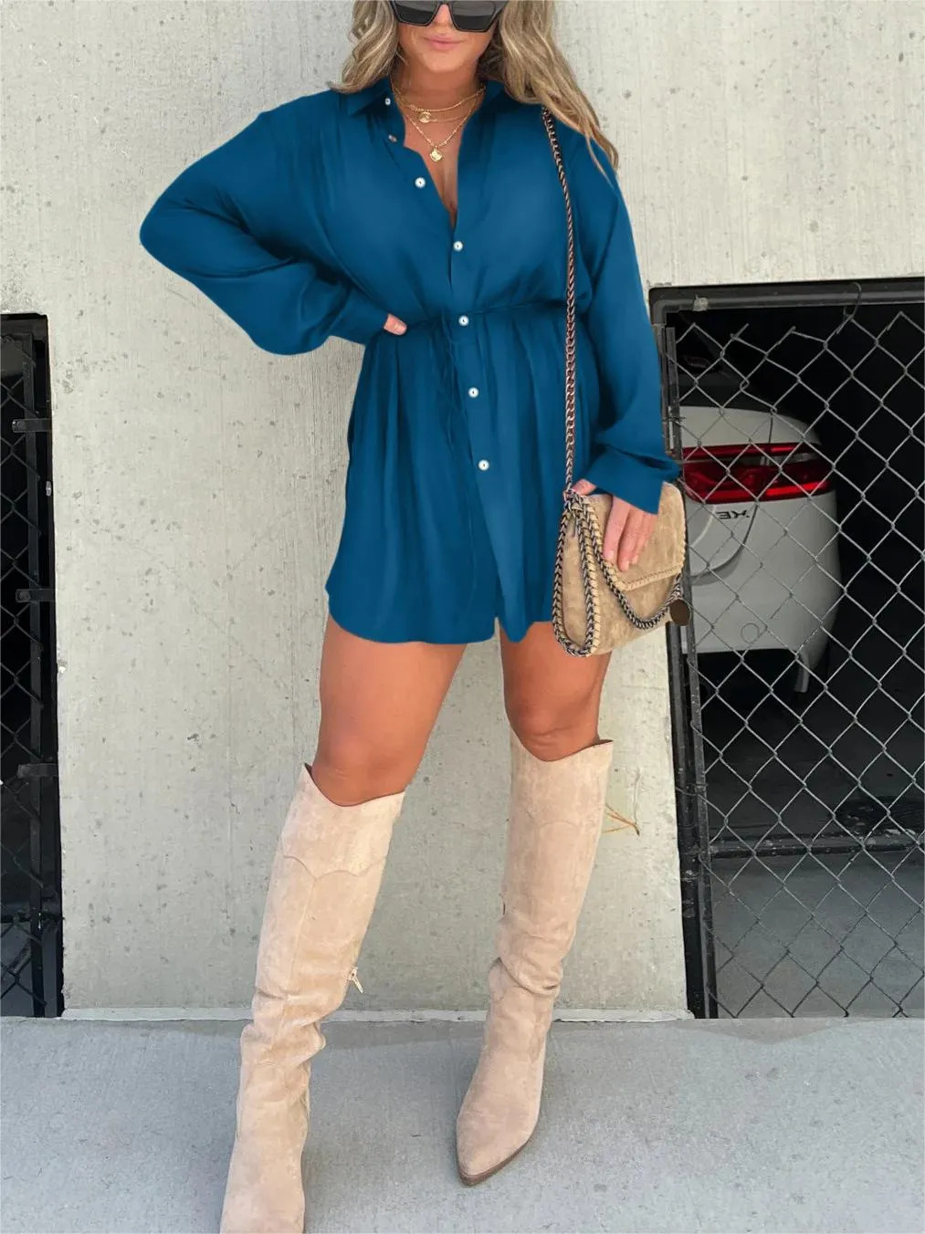 Blue - Woman wearing a long sleeve button front shirt dress with an adjustable tie waist.