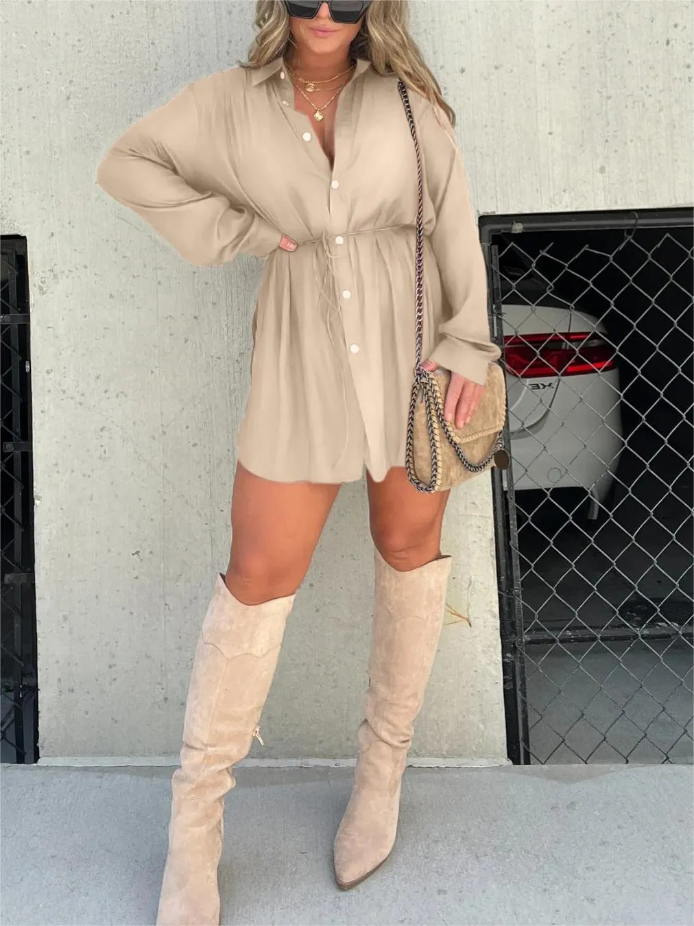 Apricot - Woman wearing a long sleeve button front shirt dress with an adjustable tie waist.