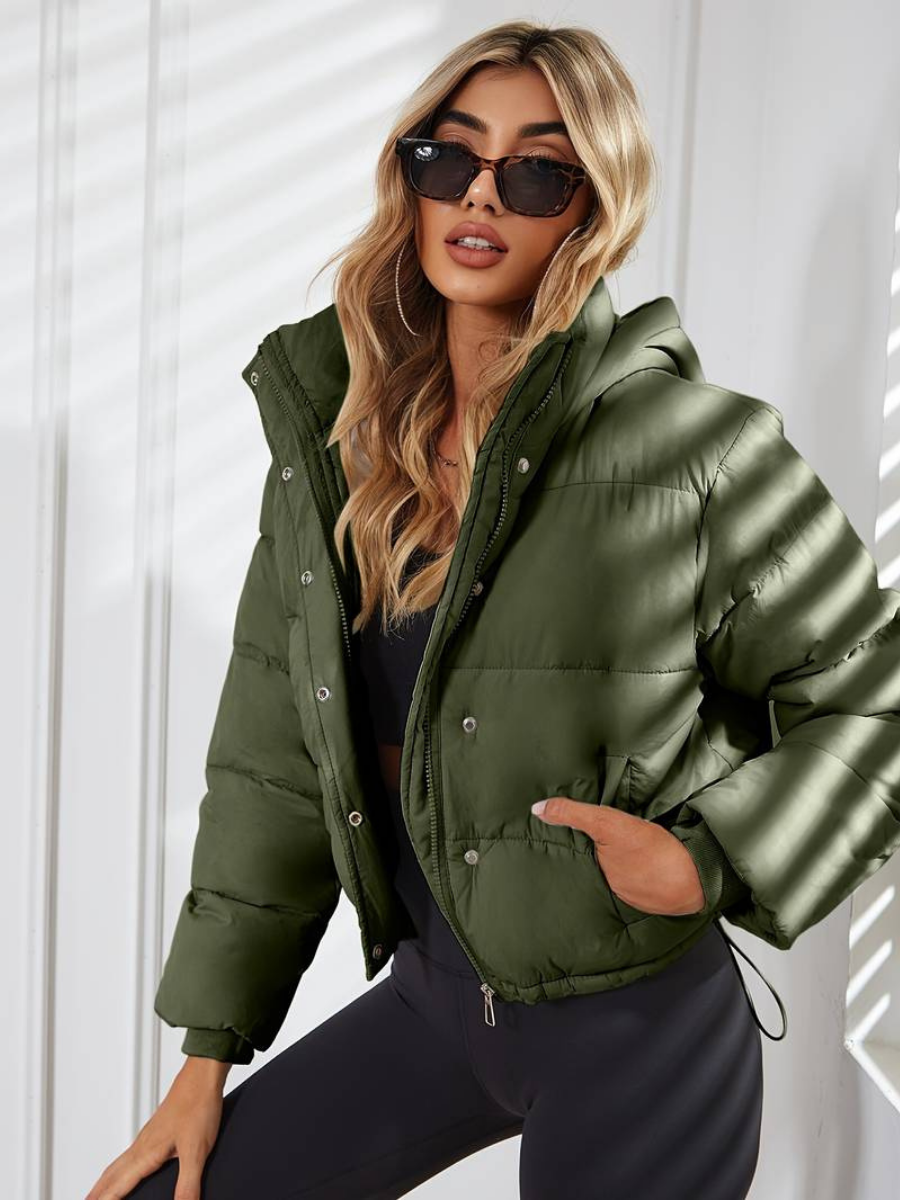 Olive Green - A woman wearing a chocolate brown cropped puffer jacket with a hood, styled over a black sports bra and high-waisted black leggings.