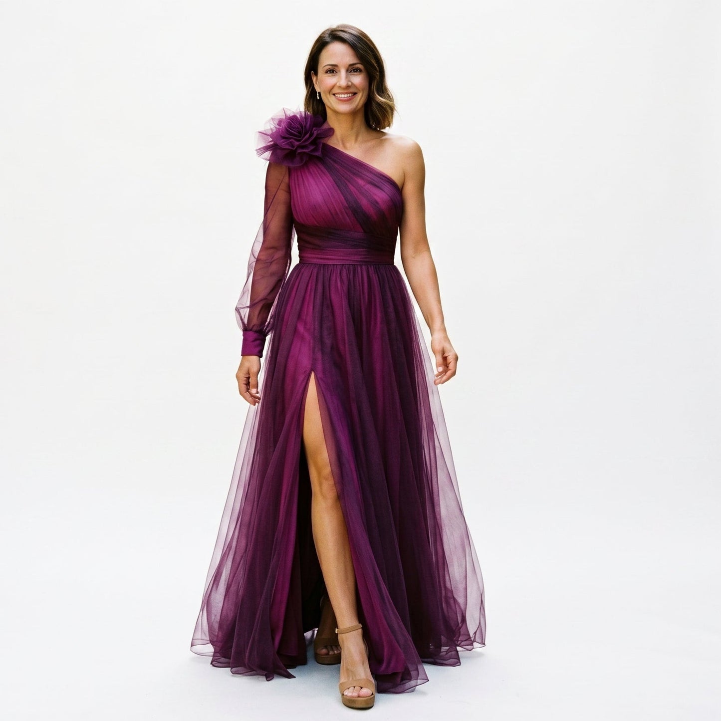 Dark Violet - A woman wearing a floor-length, one-shoulder maxi dress in a green and purple abstract floral print, featuring a large 3D flower on the shoulder, a single sheer long sleeve, and a high leg split.