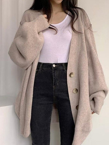 Beige - Women's oversized ribbed knit cardigan featuring a V-neckline, large button closures, and voluminous balloon sleeves with fitted cuffs, styled open over a black top.